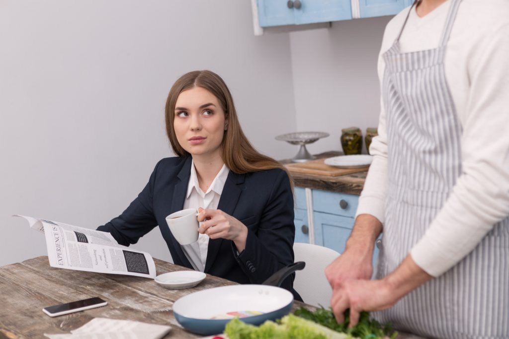 Pleased woman having her morning coffee served by man